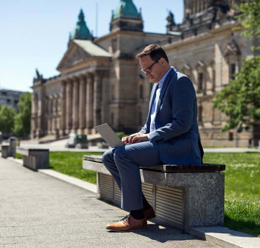 Dirk Panter arbeitet draußen an einem Laptop